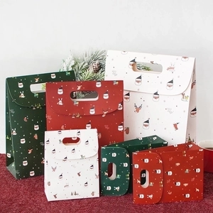 Various Christmas gift bags with Santa and reindeer patterns in red, green and white colors