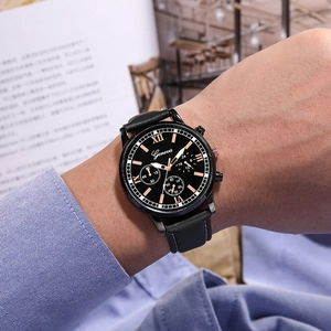 Montre homme d'affaires ultra-mince avec cadran noir et bracelet en cuir sur un livre