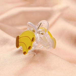 Cute banana acetate hair claw clip for kids on a soft pink background fabric