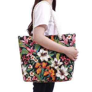 Detail of tropical floral print tote bag with thick rope handles and silver metal eyelets