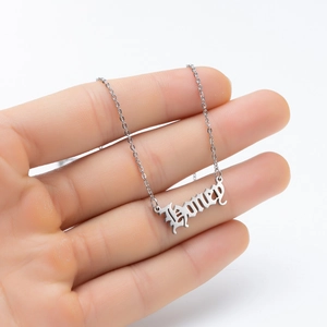Silver gothic Honey letter pendant necklace in stainless steel held by hand