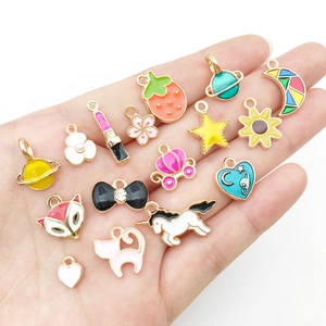 Macro shot of colorful enamel charms featuring stars, hearts and moons on metal bases