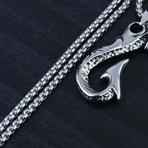 Detailed view of silver fish hook pendant with scale texture on a venetian chain