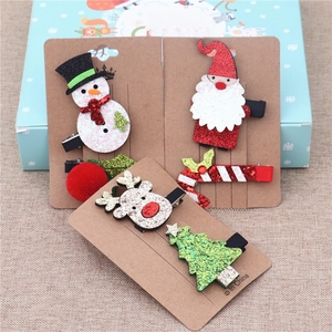 Detailed view of Christmas hair clips featuring snowman and reindeer holiday designs