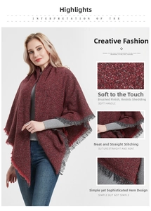 Macro shot of deep burgundy knitted shawl fabric featuring gray fringe and fine texture