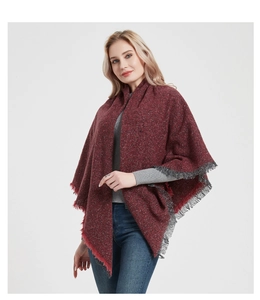 Detail of wine red tweed shawl with tassel fringe edges worn by a blonde model