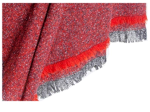 Detail of red and grey boucle fabric showing tweed texture and fringe tassels