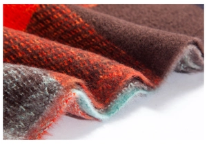 Gros plan du tissu d'écharpe à carreaux avec fibres de laine rouges et bleues douces