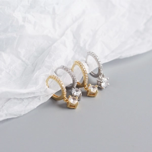 Close-up of gold and silver S925 sterling silver earrings with square zircon pendants