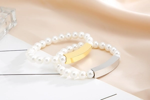 Detailed view of pearl bracelets with gold and silver bars on elegant silk fabric