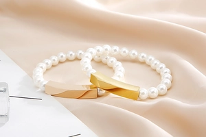 Detail of elegant pearl bracelets with twisted gold and rose gold metal bar accents