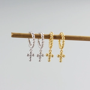 Macro detail of silver and gold S925 sterling silver cross charm bead hoop earrings