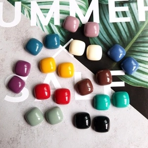 Vue à plat de breloques carrées colorées pour bijoux DIY en diverses couleurs acidulées