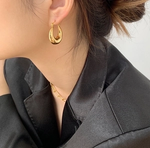 Pendientes de gota en oro de 18K y collar de cadena gruesa mostrados en una modelo real