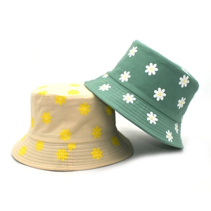Détail de chapeaux bobs en coton avec motifs marguerites et bords à coutures renforcées