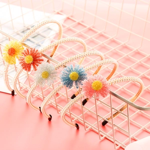 Macro view of multi-colored pearl beaded headbands with floral accents in a basket