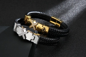 Detail of woven black leather bracelets with gold and silver crystal inlaid metal plates
