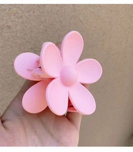Close-up of matte pink flower hair claw clip with delicate frosted resin finish