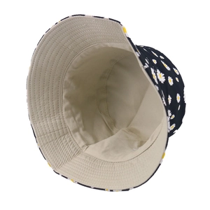Reversible daisy bucket hat with black floral print and beige cotton lining for sun protection