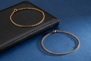 Detail of minimalist gold-plated stainless steel cable chain bracelet with lobster clasp