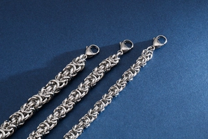 Detailed view of three silver stainless steel braided link bracelets with lobster clasps