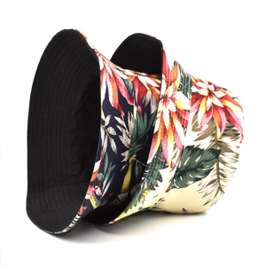 Dettagli della stampa floreale tropicale e cuciture su cappelli a secchiello in cotone double face