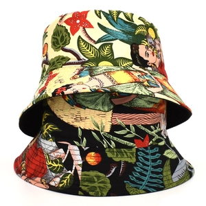 Close-up of cotton bucket hats featuring Frida Kahlo portrait and tropical leaf patterns