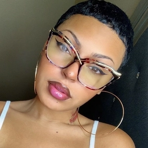 Close-up of tortoise shell cat-eye glasses and oversized gold hoop earrings on a model