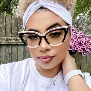 Cat eye glasses frames with two-tone black and pink design and metal studs on a model