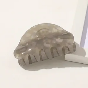 Detail view of large marble texture hair claw clip with grey and beige acetate finish