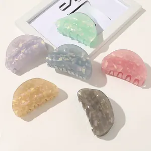 Close-up of acetate shark hair claws in assorted pastel colors with gold foil flakes