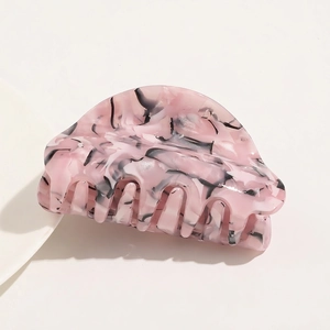 Detail view of pink marble acetate hair claw clip with strong teeth for hair styling