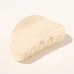 Close-up of beige marble texture acetate hair claw clip with smooth polished finish