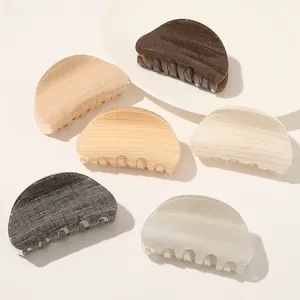 Detailed view of six textured acetate hair claws in wood and marble patterns