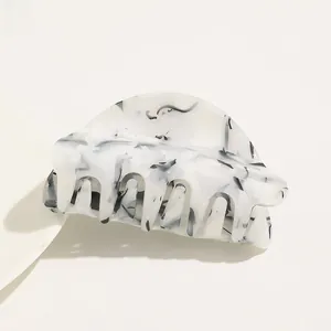 Detailed view of large acetate hair claw clip with black and white marble pattern