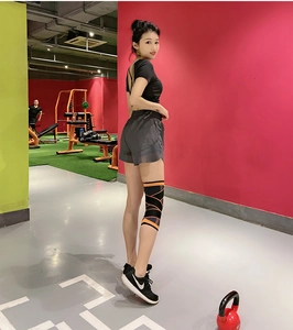Détail de la genouillère de sport avec motif croisé orange sur un athlète professionnel