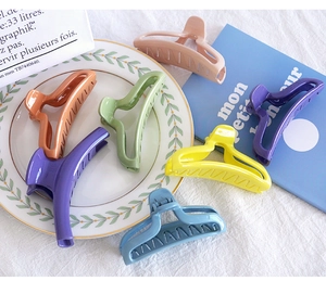 Collection of colorful large hair claw clips in various pastel candy colors on a table