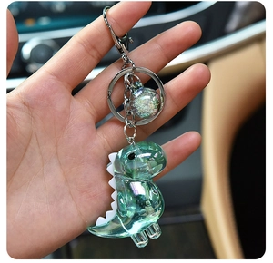 Macro view of holographic green acrylic dinosaur charm with shimmering sequin pendant