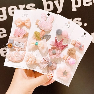 Roze kinderhaarclips set met strikjes en sterren gepresenteerd op een zwarte wand