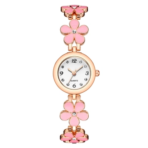 Macro view of pink enamel flower band and sparkling rhinestone dial on quartz watch