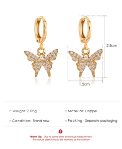 Détail des boucles d'oreilles papillon dorées avec zircons et mesures de 2,5 cm de haut
