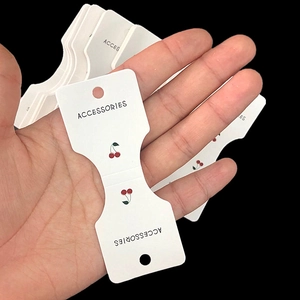Handheld white paper card with cherry print for hair accessory and jewelry packaging