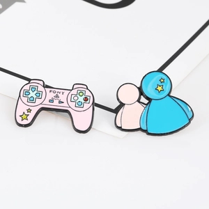 Detail of pink game controller enamel pin and cute character badge on white card