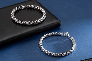 Detailed close-up of polished silver box chain bracelet with secure lobster clasp