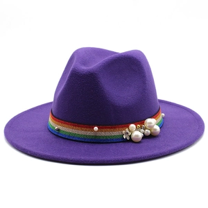 Detail of purple fedora hat featuring rainbow ribbon band with white pearls and gold accents