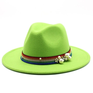 Detail of green wool fedora hat featuring rainbow glitter ribbon and pearl floral accents