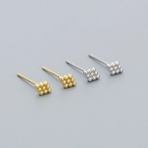 Macro shot of 925 sterling silver studs in gold and silver showing the S925 hallmark