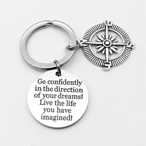 Close-up of stainless steel keychain with compass charm and engraved Drive Safely metal tag