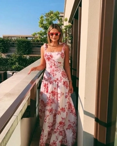 Detail of white maxi dress with red floral print featuring shoulder bow tie straps