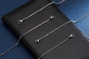 Detailed view of silver stainless steel O-chains with lobster clasps on black leather